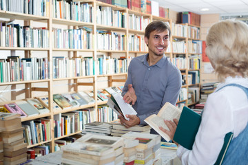 young male seller in book shop.