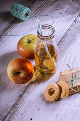apple juice in bottle and biscuits on white table