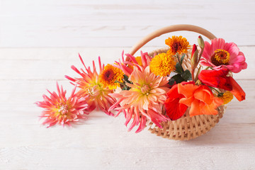 Fototapeta na wymiar summer flowers in basket on wooden table
