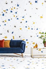 Colorful lastrico stickers pattern on a white wall and floor of a modern living room with a navy...
