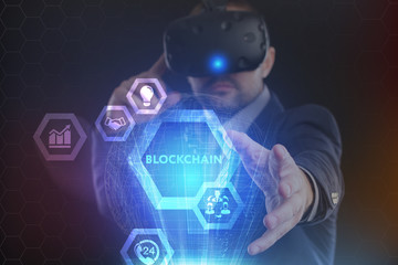 The concept of business, technology, the Internet and the network. A young entrepreneur working on a virtual screen of the future and sees the inscription: blockchain