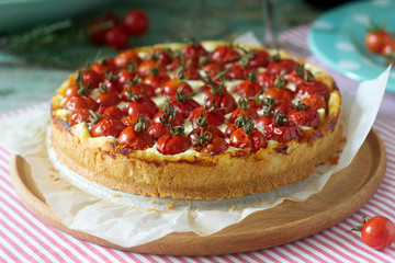 Tart, pie or cheesecake with cottage cheese and tomatoes, served with red wine on a wooden background.