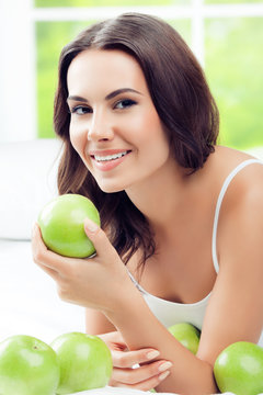 happy smiling woman with green apples, indoors
