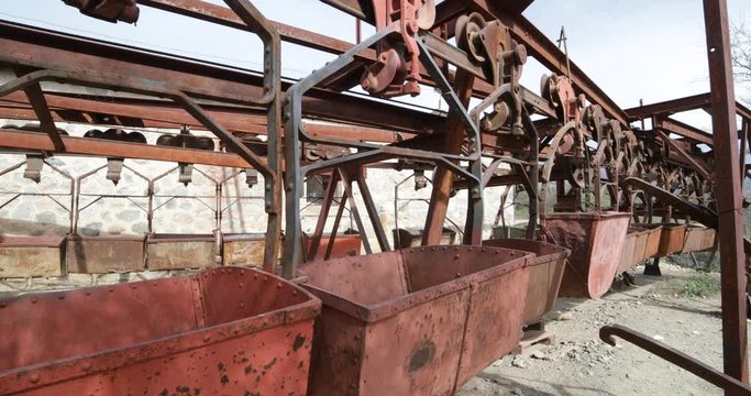 Second station of old Cable Car Chilecito-La Mejicana mine. Detail of rusty iron wagons. Camera moves sideways slowly linear disposition of wagons. National industrial heritage