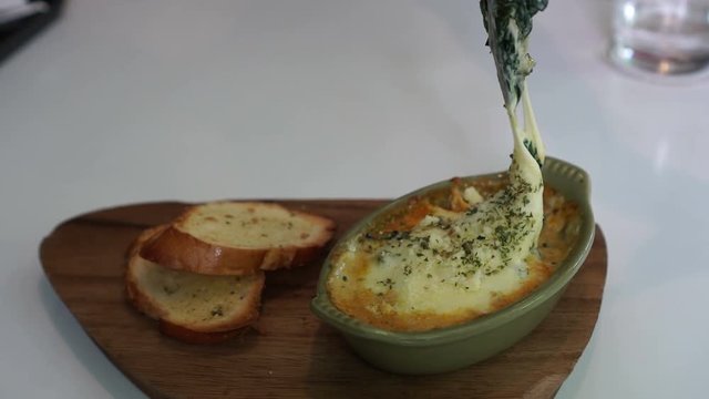 Fork eating baked spinach with melty cheese video 4k