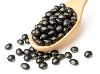 uncooked black bean in the wooen spoon, isolated on white