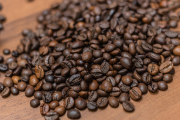 Background of fried coffee beans on a wooden surface