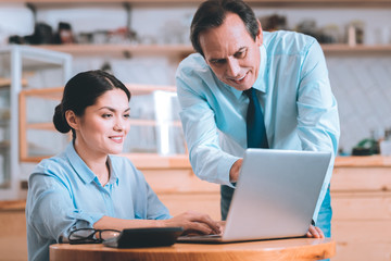 Obraz premium Have a look. Delighted female person keeping smile on her face while listening to her boss