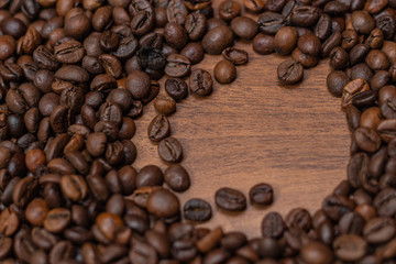Background of fried coffee beans on a wooden surface
