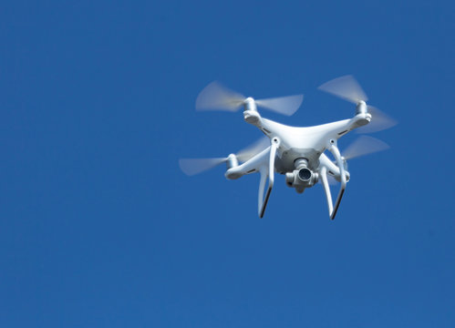 drone tetracopter flying isolated in blue sky