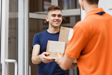A person wearing an orange T-shirt is delivering parcels to a sa
