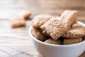 Cookies crackers square shape in a plate on a wooden table.