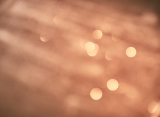 New Year Christmas Blurred background. Abstract defocused gold, white, red and yellow glitters texture on black background. Shining glowing snow effects