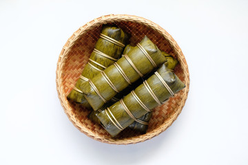 Glutinous rice steamed in banana leaf in bamboo bowl on white background.