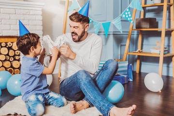 Fight robots. Satisfied attractive man shouting while celebrating birthday with son