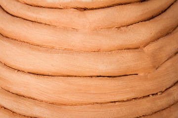 Close up of unglazed coiled pottery pot made of red clay