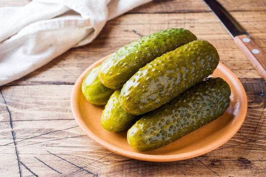 Pickled cucumbers in a wooden bowl dark rustic background