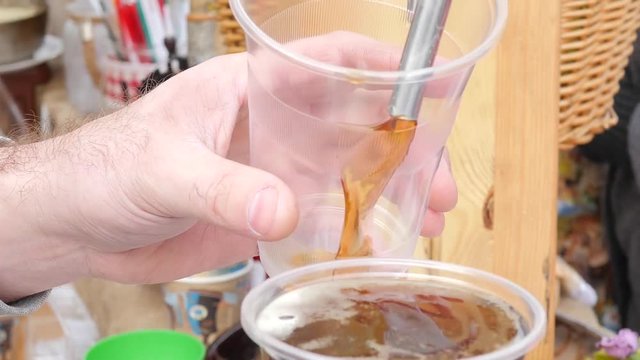 Bar man pouring a beer in a cup in a street food market fair