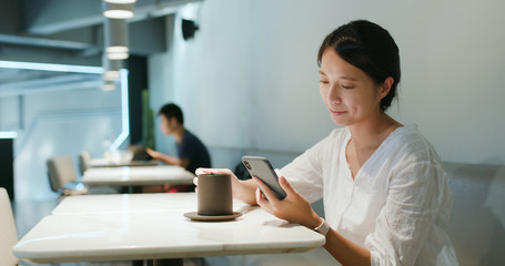 Woman use of smart phone in coffee shop