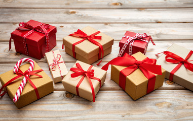Gift boxes with red ribbons on wooden background, copy space