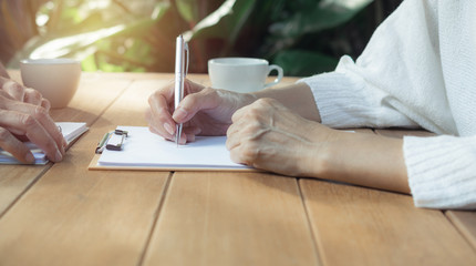 Business man and woman teamwork meeting in the morning to work and talk about they plan in the future on wooden in garden background.