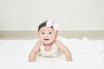 Baby girl smiling on the floor isolated on white