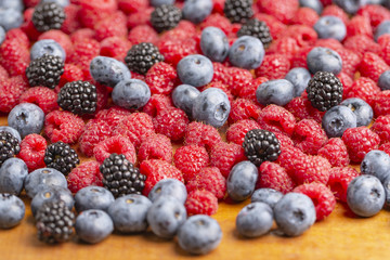 Raspberry, BlackBerry and blueberry on wooden background