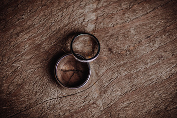 Two wedding rings on a wooden surface