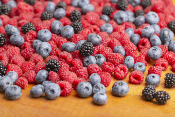 Raspberry, BlackBerry and blueberry on wooden background