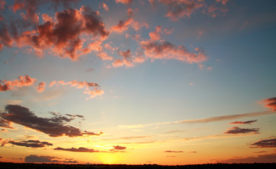 Colorful dramatic sunset on sky with bizarre clouds