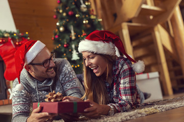 Obraz na płótnie Canvas Couple exchanging presents on Christmas morning