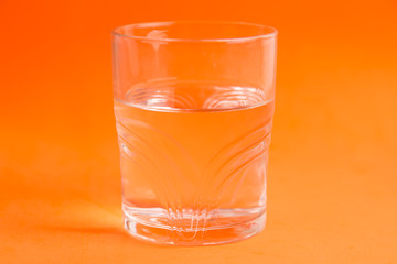 glass of water in color background