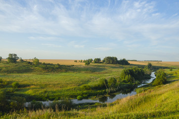 Beautiful summer landscape with river, green hills,fields and woods