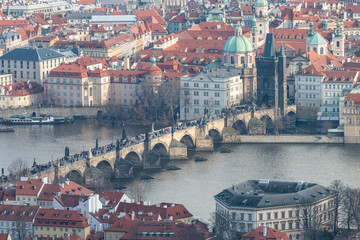 Obraz premium View of Charles Bridge, Old Town Bridge Tower and Church of St. Francis of Assisi. Beautiful Prague cityscape with classic red roofs, Vltava river and famous Czech showplaces.