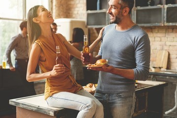 Party with best friends. Group of cheerful young people enjoying home party with snacks and drinks while communicating on the kitchen.
