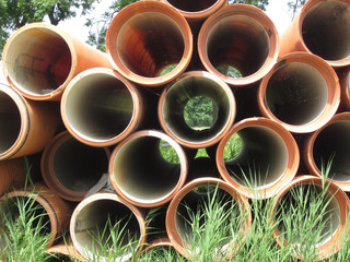 landscape seen through orange colored sewer pipes