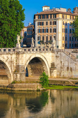 View on the Sant Angelo bridge over the Tiber river in Rome, Italy on a sunny day.