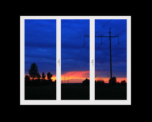 Plastic windows overlooking beautiful crimson sunset. View from home window