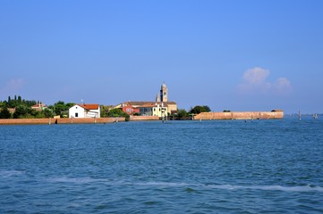 Piccolo paese sulla riva del mare con campanile di antica chiesa