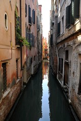 Vicolo della città di Venezia con antiche case ed canale di navigazione