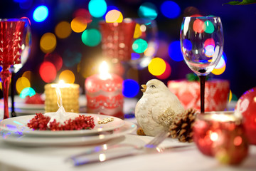 Beautiful table setting for Christmas party or New Year celebration at home. Cozy room with a...