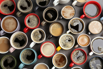 Many cups with tasty aromatic coffee on table, flat lay