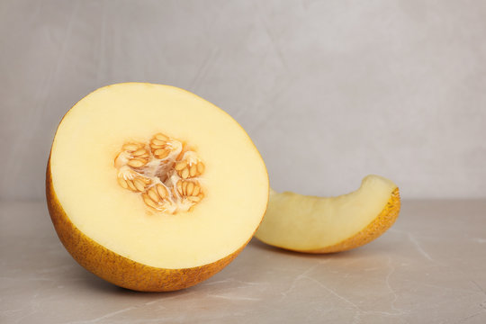 Cut sweet melon on table against gray background. Space for text