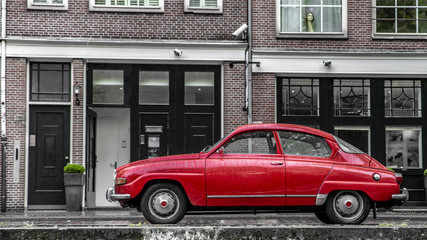 красная машина на дождливой улице Амстердама, Голландия