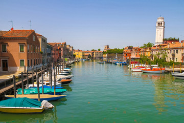 Fototapeta premium View on the historic architecture and the canal between the ancient buildings in Venice, Italy on a sunny day.