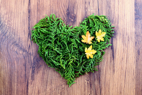 Love autumn decoration with twigs forming a heart on wooden background