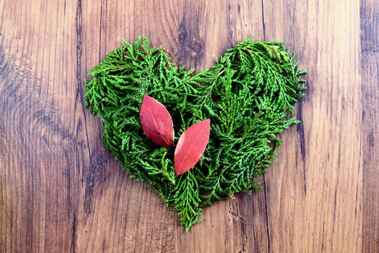 Love autumn decoration with twigs forming a heart on wooden background