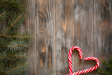 festive cozy christmassy atmosphere. minimalistic holiday decor. fir tree branch and candy cane in...