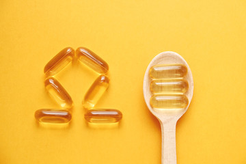 Omega 3 symbol laid with fish liver oil capsules. Close up of big golden translucent in form of...