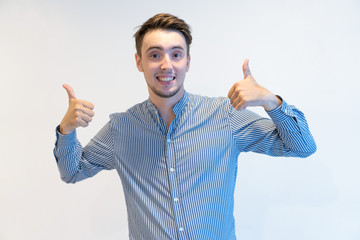 Cheerful ecstatic man showing thumbs-up and looking at camera. Positive successful guy gesturing...